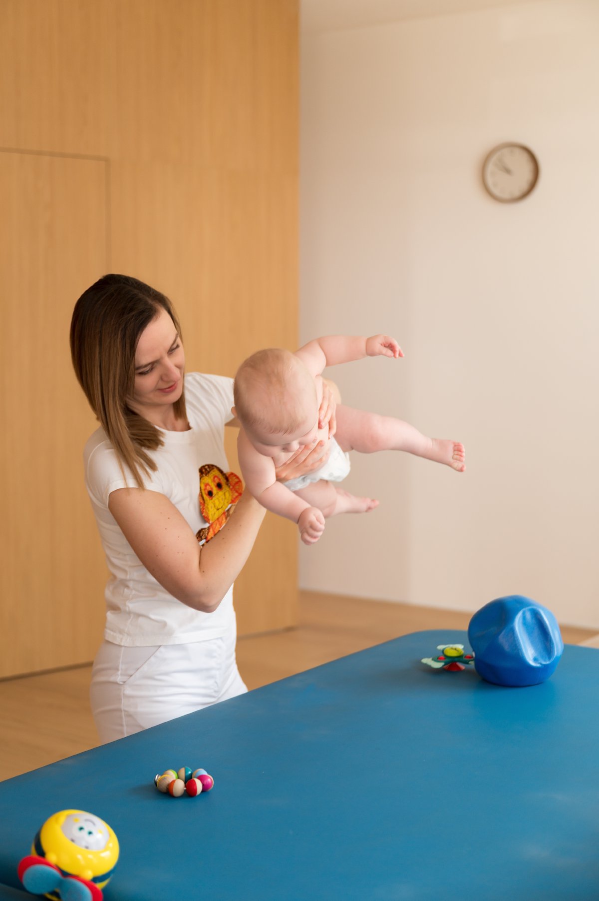 Fyzioterapeutka drží bábätko pri vyšetrení